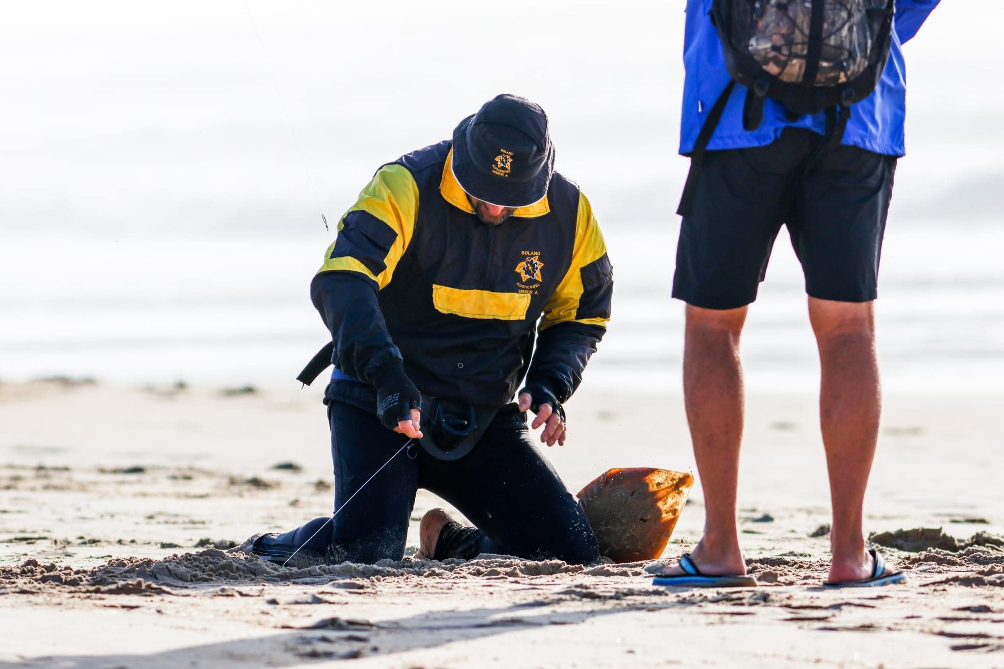 A club angler landing a catch on the beach